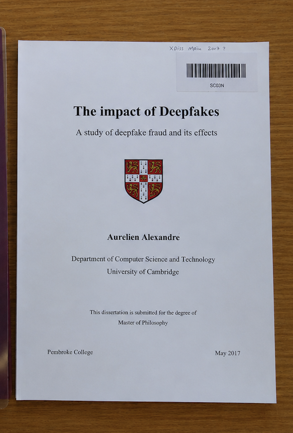 Thesis title page for The impact of Deepfakes on a wooden desk